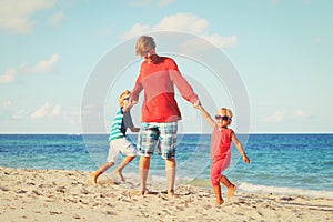 Father with son and daughter play at beach