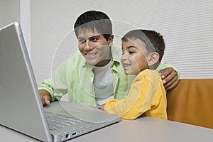 Father and Son at desk Using Laptop close up