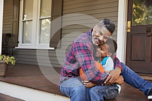 Father And Son Discussing Basketball On Porch Of Home