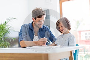 Father and son doing homework together photo