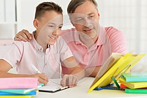 Father and son doing homework together at home