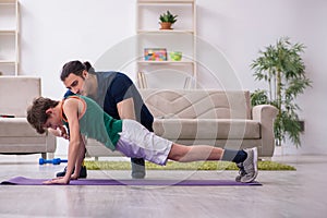 Father and son doing sport exercises indoors