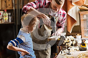 Father and son with drill working at workshop