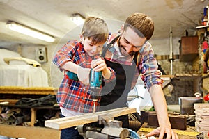 Father and son with drill working at workshop photo