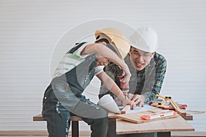 Father and son drilling wood on workshop table for home improvement, for family bonding father and son love concept