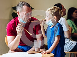 Father and son eat chocolate dessert with spoons in Cafe. Spending time together. Sweet tooth. Happy childhood