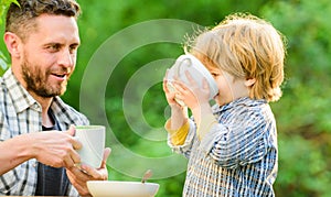 Father and son eat outdoor. healthy food. Family day bonding. small boy child with dad. they love eating together