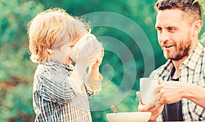 Father and son eat outdoor. healthy food. Family day bonding. small boy child with dad. they love eating together