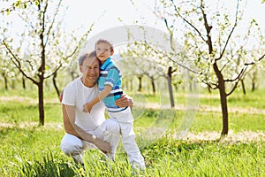 Father and son embrace in the garden in the spring of summer.