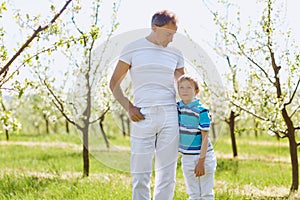 Father and son embrace in the garden in the spring of summer.