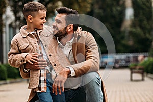 Father and son embracing and looking at each other on street