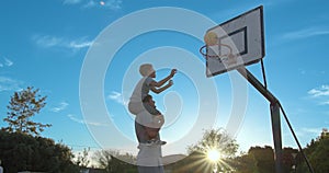Father with son enjoy a day at the park and playing basketball.