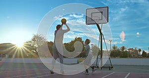 Father with son enjoy a day at the park and playing basketball.