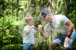 Father and Son Enjoying Playful Fist Bump in Lush Forest