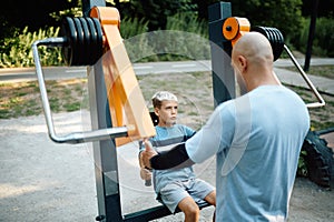 Father and son on exercise machine, sport training