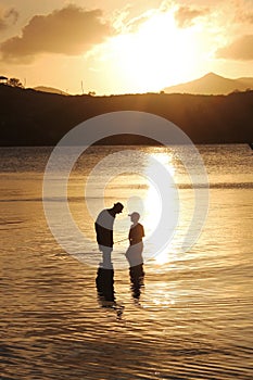 Father and son family fishing at sunset