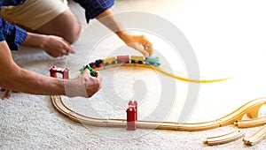 Father and son family time together at home concept. Bearded olf Father and Bearded middle age Son Playing Toy train on floor at