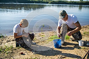 Father and son fishing on the lake together.