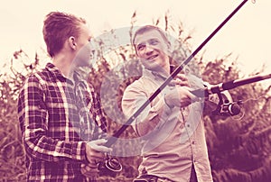 Father and son fishing on river