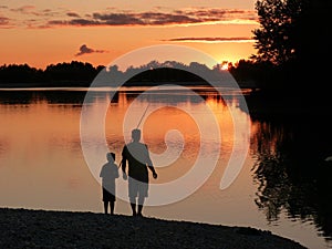 Father and son fishing at sunset