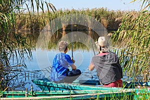 Father and son fishing together from boat