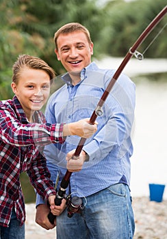 father and son fishing together on lake .
