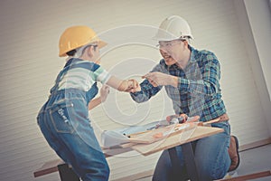 Father and Son fist bump for success concept in construction industry concept in vintage tone, Daddy and kid hand together for