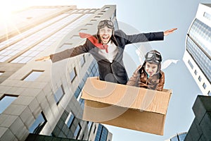 Father and son flying in a cardboard box