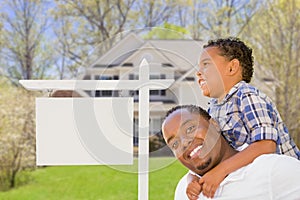 Father and Son In Front of Blank Real Estate Sign and House