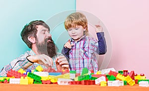 Father son game. Dad and kid build plastic blocks. Child care development. Family leisure. Father and son create photo