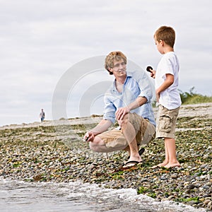 Father and son gathering rocks at beach