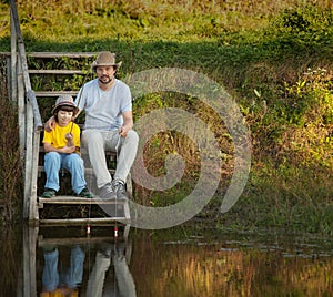 Father and son go fishing on the lake, family vacation on the ri