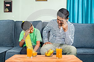 Father and son got upset while watching live cricket game at home due to loss of match or wicket - concept of