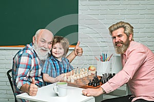 Father and son with grandfather playing chess, back to school. Men generation. Fathers day.