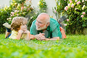 Father son and grandfather relaxing together. Happy family father and child on meadow with a kite in the summer on green