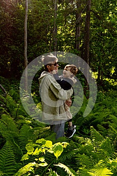 Father and son in green fern forest.