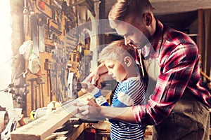 Father and son with hammer working at workshop