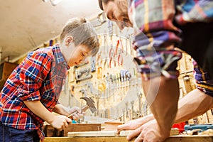 Father and son with hammer working at workshop