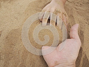 Father and son hands on sand. Close up