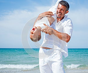 Father and son having fun on the beach