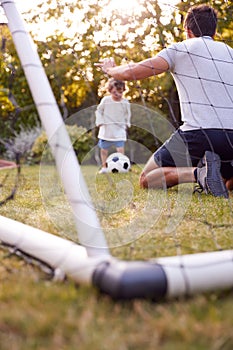 Father With Son Having Fun In Park Or Garden Playing Soccer Together