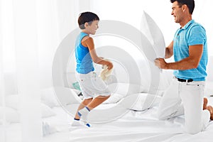 Father and son having fun. Pillow fight