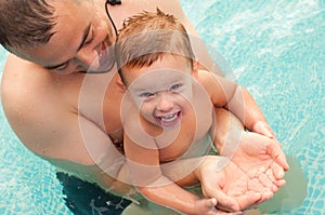 Father and son having fun in the swimming pool