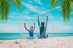 father and son having fun on tropical beach