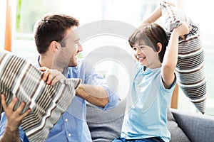 Father and son having pillow fight