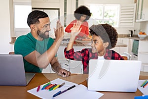 Father and son high fiving each other at home