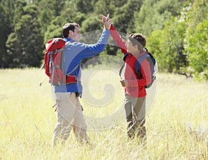 Father And Son On Hike In Beautiful Countryside Giving High Five