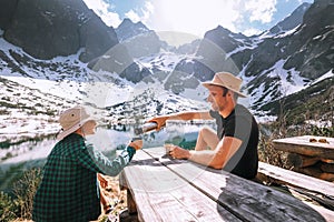 Father and son hiking traveler rest and drink tea near the mount