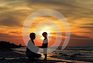 Father and son holding hands at sunset