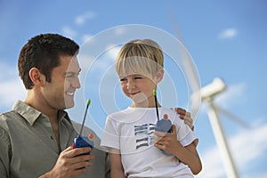 Father And Son Holding Toy Walkie-Talkies